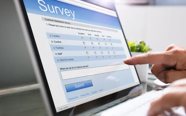 Screenshot of an online customer satisfaction survey form. A hand is pointing at the form